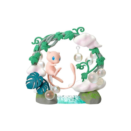 A pink Pokémon figurine is sitting on a rock, surrounded by various decorative elements such as leaves, bubbles, and a waterfall.