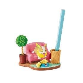 A pink couch with a cartoon character sitting on it, a potted plant, and a blue pencil holder with a pencil inside.