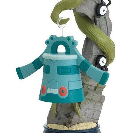 A figurine of a blue and green robot-like character hanging from a hook, with a green vine-like object attached to it.