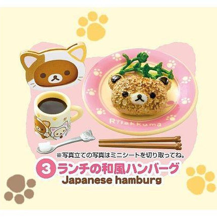 The image is a collage featuring a plate with a bear-shaped pastry, a cup of coffee, chopsticks, and paw prints. The background is a light pink color with yellow paw prints scattered around.