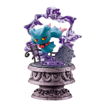 A figurine of a blue creature with red accents, resembling a Pokémon or similar character, is displayed on a decorative pedestal with purple and purple-like elements.