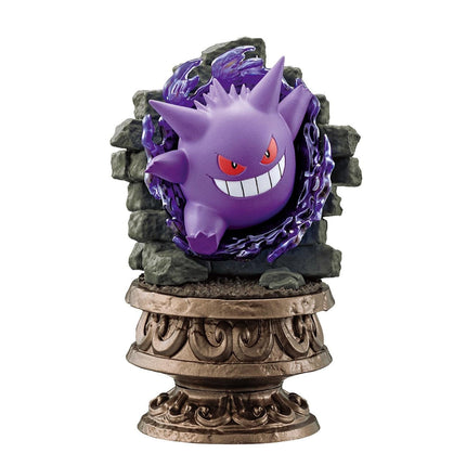 A purple figurine of a character with red eyes and a wide smile, sitting on a decorative base.