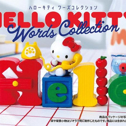The image is a promotional poster for the Hello Kitty Words Collection, featuring a Hello Kitty figurine and various colorful objects arranged to spell out the word "Hello".