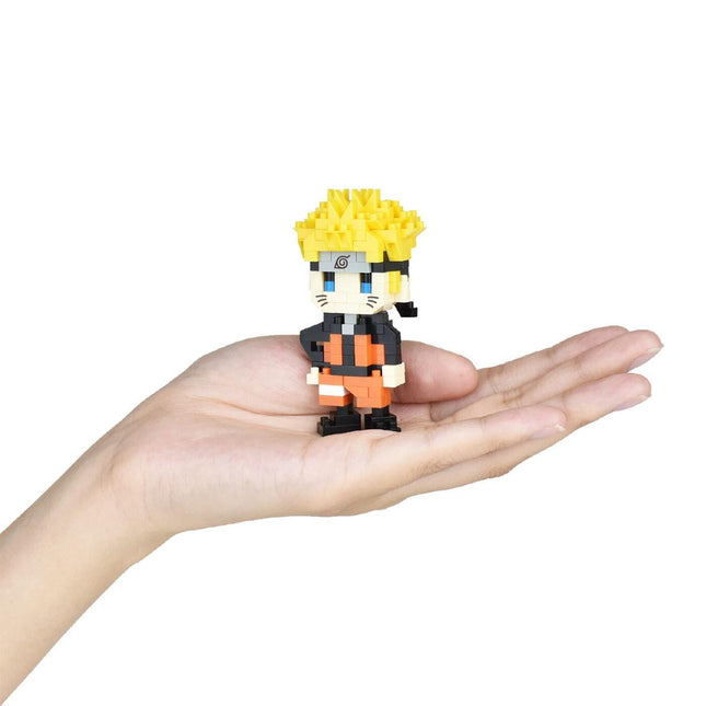 A hand holding a small, colorful, pixelated figure of a character with a yellow headband.