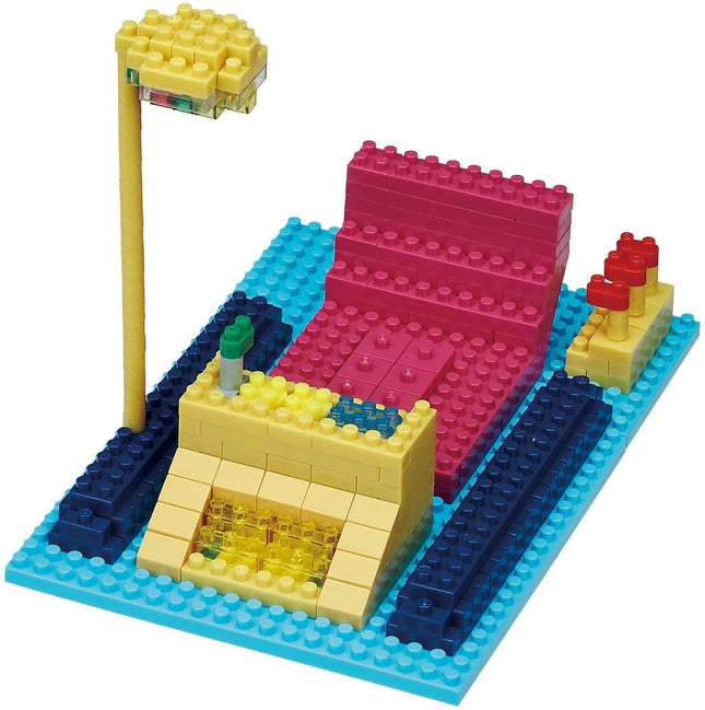 A colorful and creative arrangement of various building blocks, including a yellow lamp, a pink structure, and other blocks in different colors, all set against a blue background.