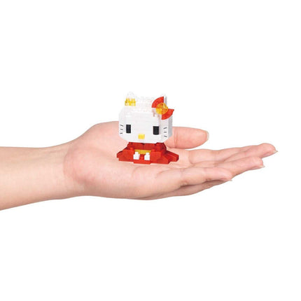 A hand holding a small white Hello Kitty figurine against a white background.