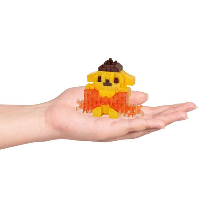 A hand holding a small yellow and orange toy, which appears to be a pixelated or block-based toy.