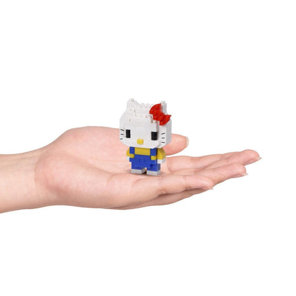 A small, white Hello Kitty figurine with a red bow is being held in a person's hand against a white background.
