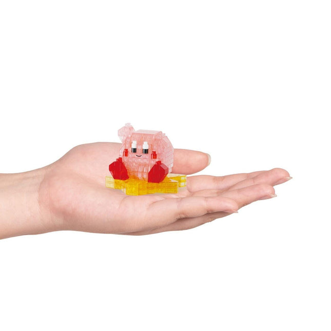 A hand holding a small, colorful toy in a pink and yellow shape.