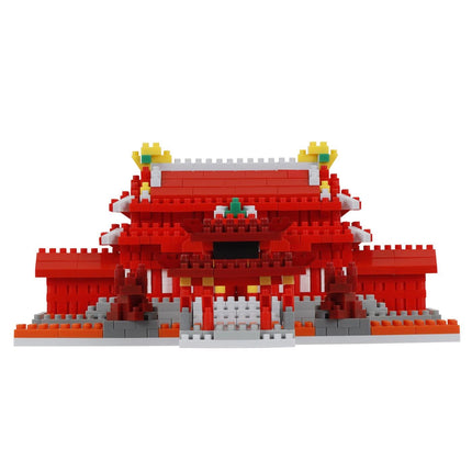 A red and white building made of red and white building blocks, with yellow and green accents, against a white background.