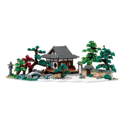 A detailed model of a Japanese-style house surrounded by a garden, featuring a pagoda, trees, and other natural elements.