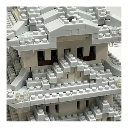 A close-up view of a complex, intricate structure made of numerous small white and gray building blocks, resembling a Lego or similar construction toy.
