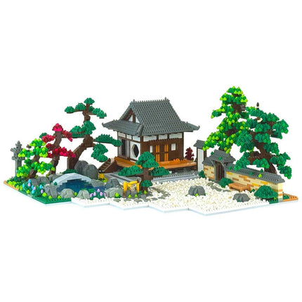 A detailed model of a Japanese-style house surrounded by a garden, featuring a pond, trees, and other natural elements.