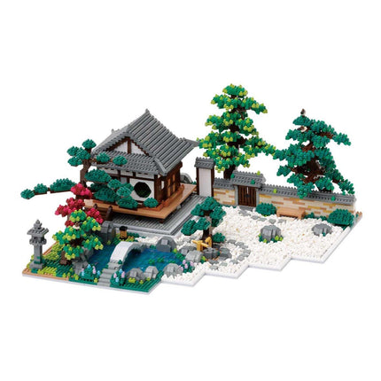 A detailed model of a Japanese-style house surrounded by a garden, featuring a pond, trees, and other natural elements.