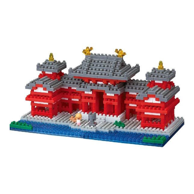 A colorful and intricate model of a temple made of building blocks, featuring red and gray accents, gold accents, and a small figure of a person.