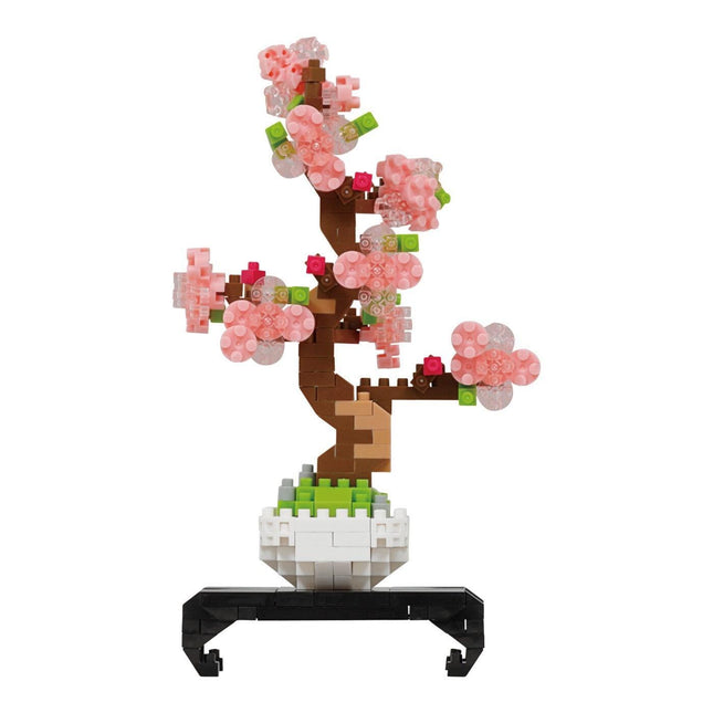 A 3D model of a pink flower arrangement in a white pot, composed of small pink and green building blocks.