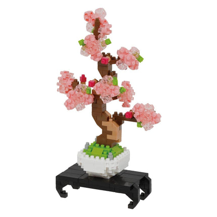 A pink flower arrangement made of small, colorful building blocks, resembling a bonsai tree.