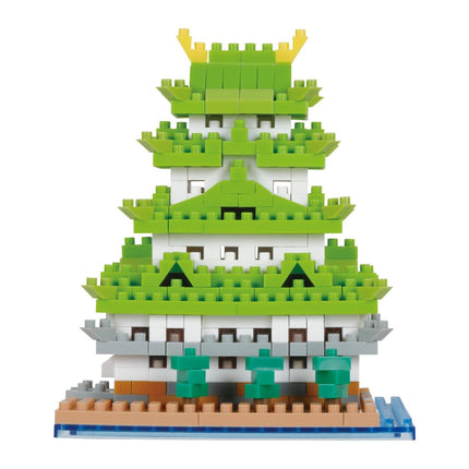 A colorful, multi-layered building made of various building blocks in shades of green, yellow, and gray.