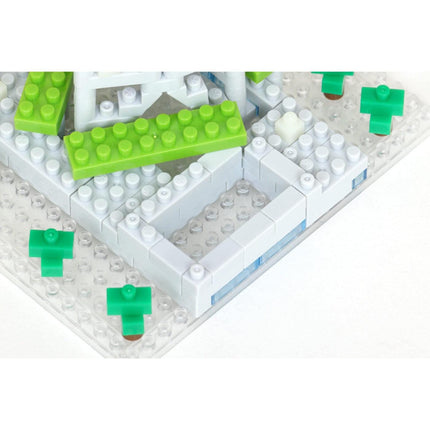 A close-up view of a white and green building block structure, with various green and white building blocks arranged in a pattern.