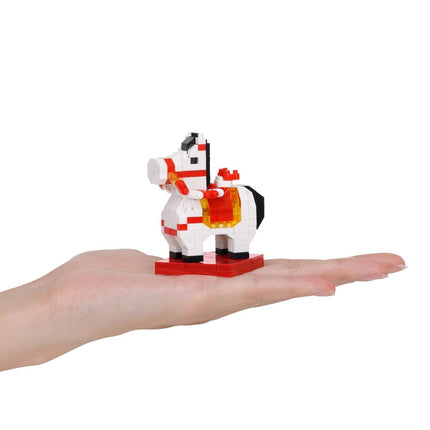 A hand holding a small, colorful, and intricate toy horse made of small building blocks.