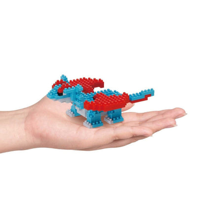 A hand holding a small toy dragon made of colorful building blocks.