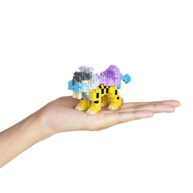 A hand holding a small, colorful, pixelated toy animal, likely a pixelated representation of a cat or similar creature.