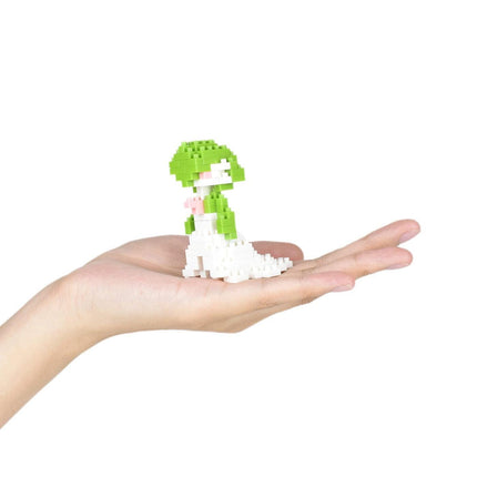 A hand holding a small green and white pixelated figure.