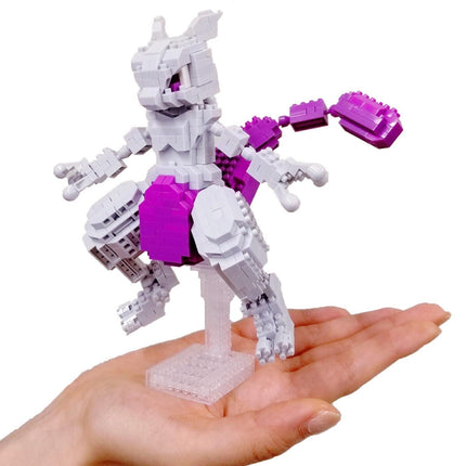 A hand holding a small, colorful toy made of small, white and purple building blocks.