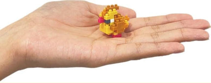 A hand holding a small yellow and orange pixelated bird-like figure.