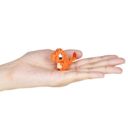 A hand holding a small orange pixelated character, likely representing a character from a video game.