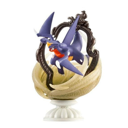 A figurine of a purple dragon-like creature with wings and sharp teeth, displayed on a decorative base.