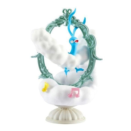 A whimsical figurine of a blue bird perched on a cloud-like structure, with musical notes and a green frame surrounding it.