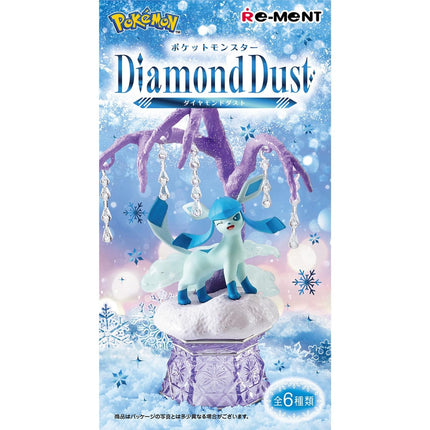 a figurine of a blue and white Pokémon character, likely a Pokémon, sitting on a snow-covered pedestal against a snowy background with snowflakes.