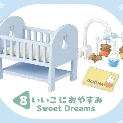 A blue crib with a mobile and a children's album, along with a group of teddy bears, are featured in the image.
