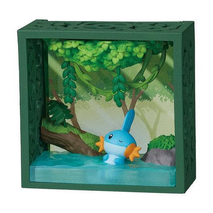 A green, three-dimensional diorama depicting a blue fish swimming in a body of water, surrounded by lush green foliage and rocks.