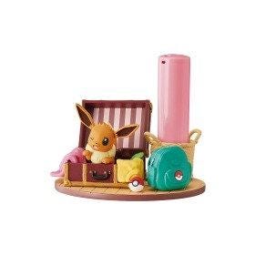 A figurine of a Pokemon character, likely Eevee, sitting inside a suitcase with various Pokemon-themed accessories, including a backpack and a power bank.