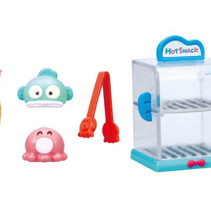 a variety of colorful toy items, including a hot dog holder, a toy fish, a toy spoon, a toy hot dog, and a toy hot dog.