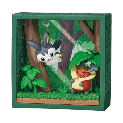 A green-framed diorama depicting two Pokemon characters, one in a tree and the other on the ground, surrounded by foliage and grass.