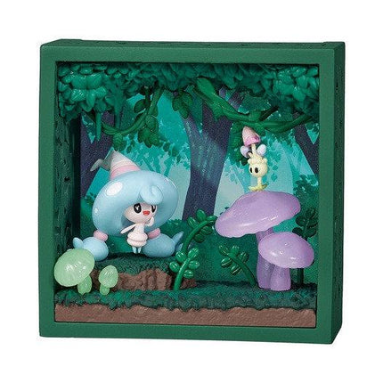 A green-framed diorama depicting a whimsical forest scene with a small blue-haired character, mushrooms, and other fantastical elements.