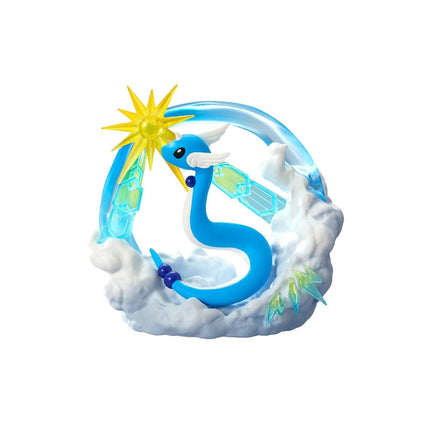A blue dragon figurine with a yellow sunburst on its head, surrounded by clouds and other fantastical elements.
