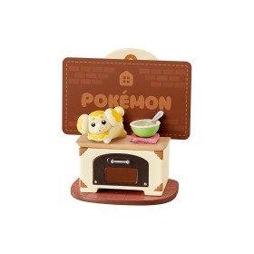 A figurine of a cartoon character, likely from the Pokemon franchise, sitting on a wooden table with a bowl and spoon.