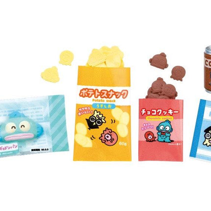 various snacks and drinks, including a can of coffee, a bag of chips, and a small package of candy.