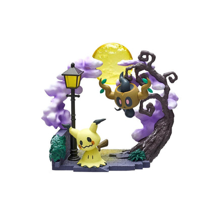 A Halloween-themed figurine featuring a yellow monster and a purple monster in a spooky, nighttime setting with a full moon and a street lamp.