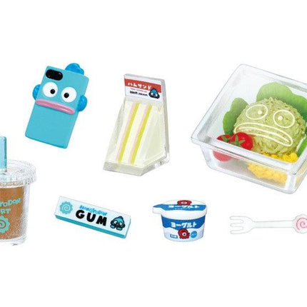various food and drink items, including a blue toy phone, a sandwich, a container with a salad, a cup with a straw, a pack of gum, and a yogurt container.