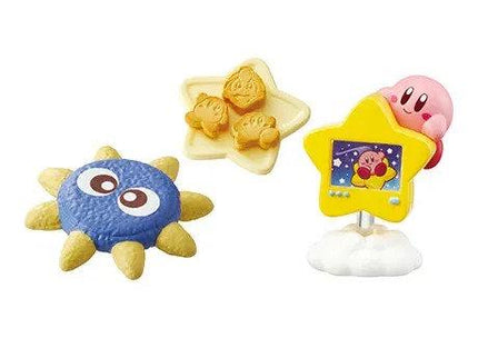 three different figurines: a blue and yellow star-shaped object, a pink character resembling a character from the Star Wars franchise, and a yellow star-shaped object with a small image of a character on it.