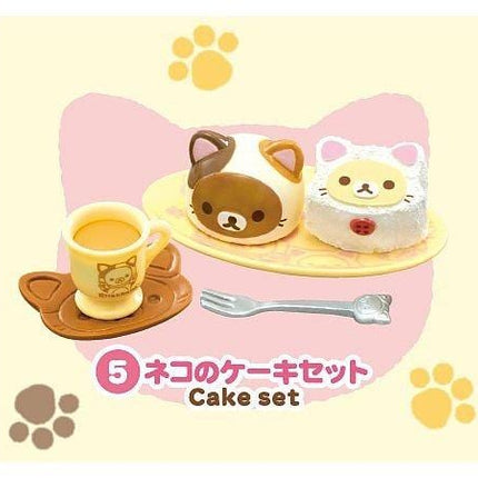 A set of three cute cat-themed cake sets, each with a cake and a cup, along with a fork and paw prints.