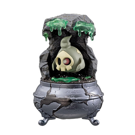 A figurine of a skull-like character with glowing green liquid dripping from its head, situated inside a cracked pot with a green substance on the ground.