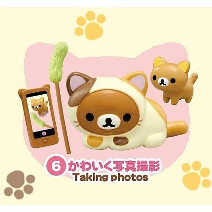 A cute cat figurine is surrounded by various objects, including a smartphone, a cat figurine, and paw prints, with the text "Taking photos" below the image.