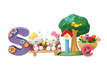 A Hello Kitty figurine sitting on a bench, surrounded by various other Hello Kitty and nature-themed accessories.