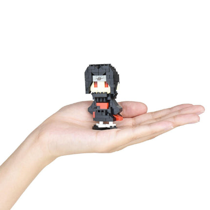 A hand holding a small, black and red pixelated figure.